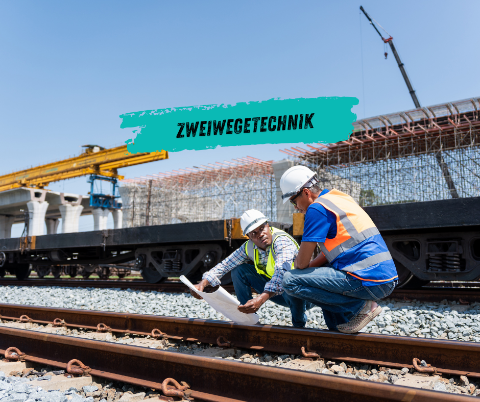 Zweiwegebagger fährt auf Schiene und Straße bei Gleisbauarbeiten