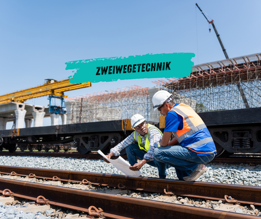 Zweiwegebagger fährt auf Schiene und Straße bei Gleisbauarbeiten